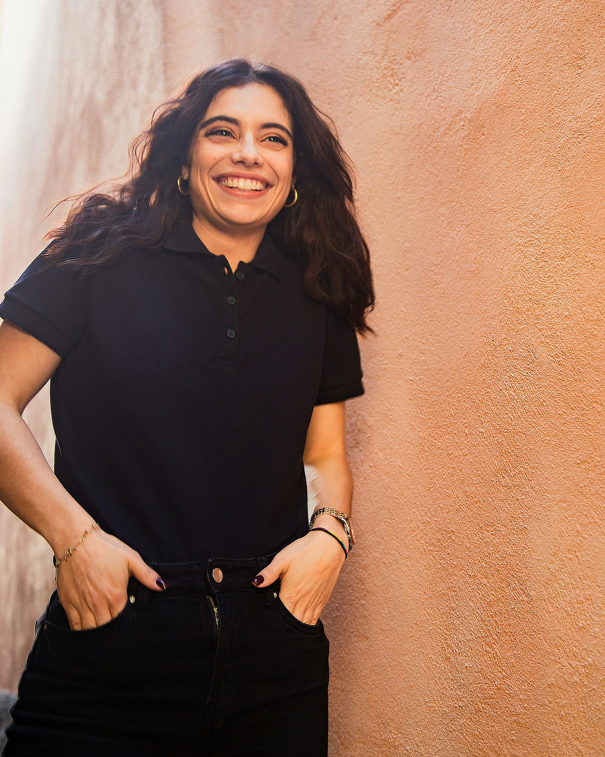 Frau trägt schwarzes tailliertes Damen-Poloshirt (Lady-Fit) – Basis für euer DTF-gedrucktes Logo
