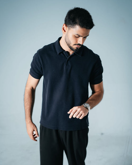 Mann trägt schwarzes Herren-Poloshirt ohne Aufdruck – Basis für euer DTF-gedrucktes Logo